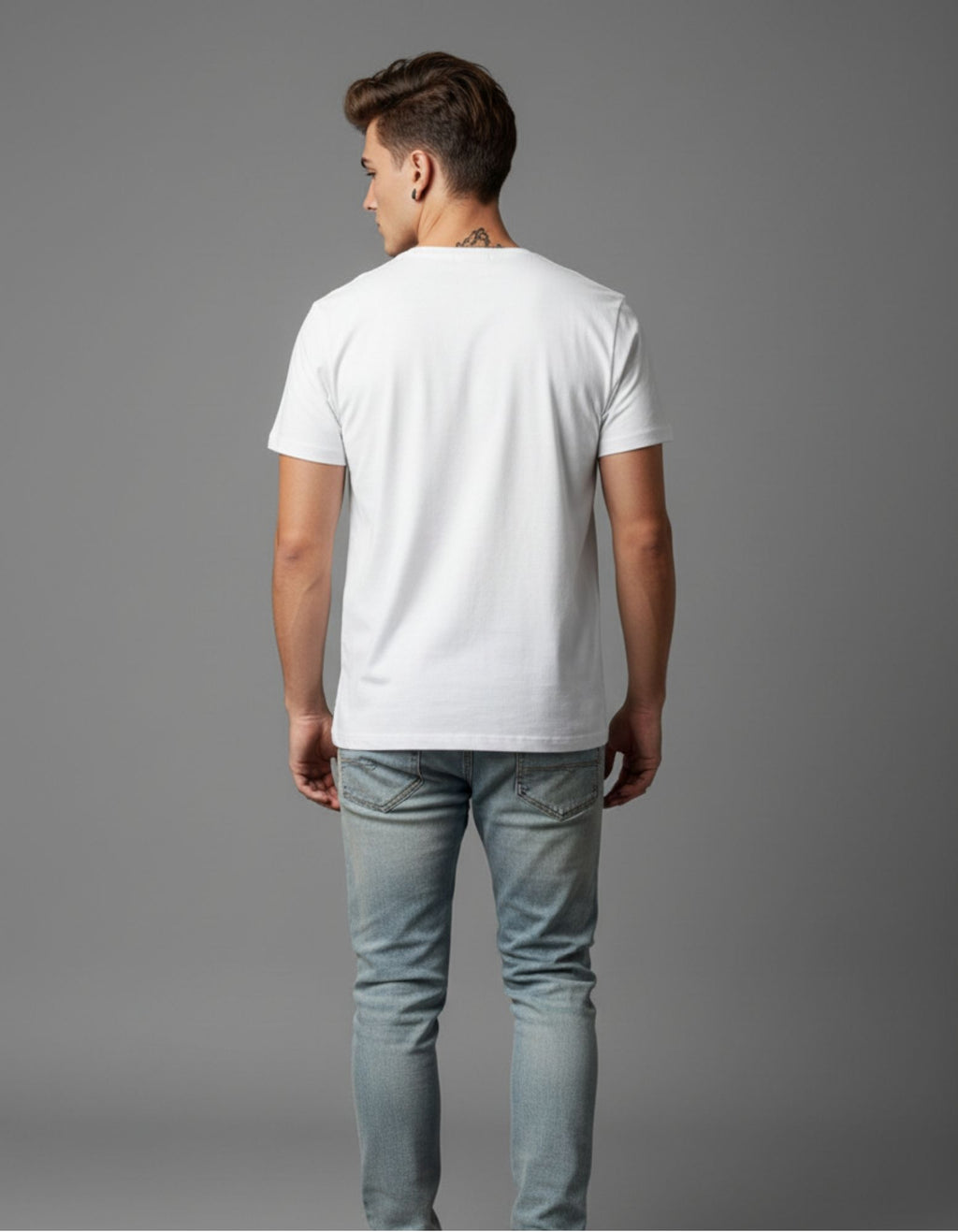 Young man wearing a white graphic T-shirt with a bold quote design that reads “I Live, I Learn” in colorful typography, paired with light blue ripped jeans and red high-top sneakers. Styled in a casual, modern look against a plain grey background.
