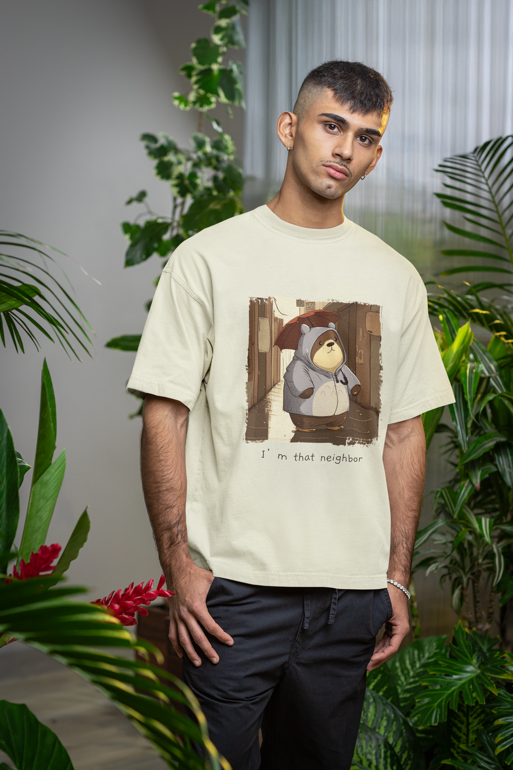 Man wearing off white 240 GSM oversized graphic t-shirt with bear holding umbrella in rain and text “I’m that neighbor.”