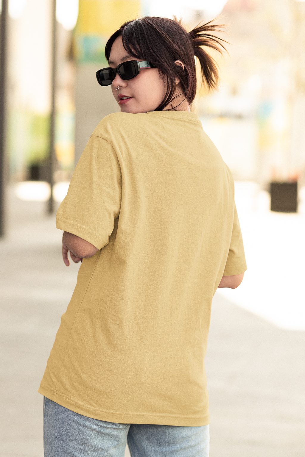 Woman wearing oversized beige T-shirt with cute fox graphic and text “You Are So Cute!” outdoors.